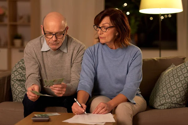 Couple aîné avec factures comptant de l'argent à la maison — Photo