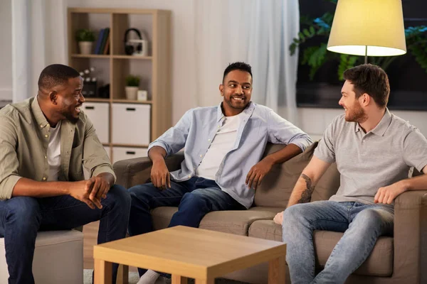 Amigos masculinos felices hablando en casa por la noche — Foto de Stock