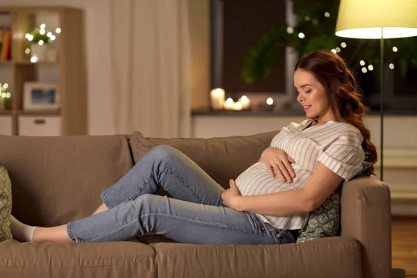 Happy smiling pregnant woman on sofa at home — Stockfoto