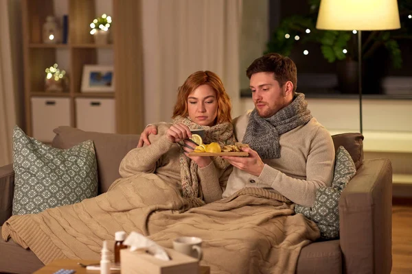 Enfermo joven pareja bebiendo té con limón en casa —  Fotos de Stock