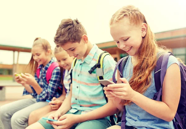 Alunos do ensino fundamental com smartphones — Fotografia de Stock