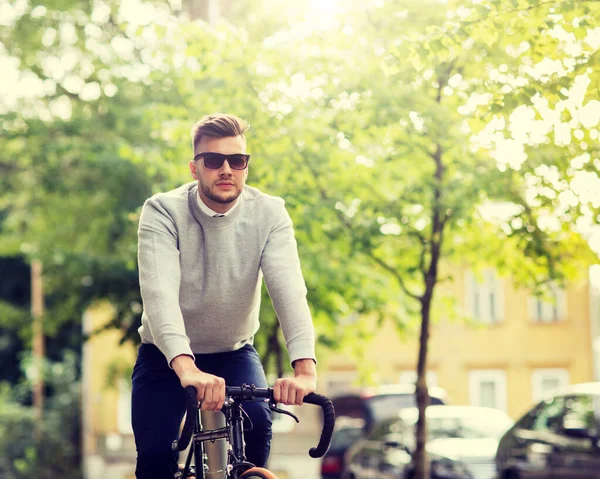 Junger Mann in Schattierungen fährt Fahrrad auf der Stadtstraße — Stockfoto