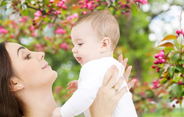 Anne ve bebek bahar bahçesi arka planında — Stok fotoğraf