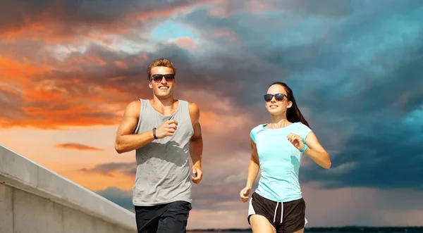 Pareja en ropa deportiva corriendo al aire libre — Foto de Stock