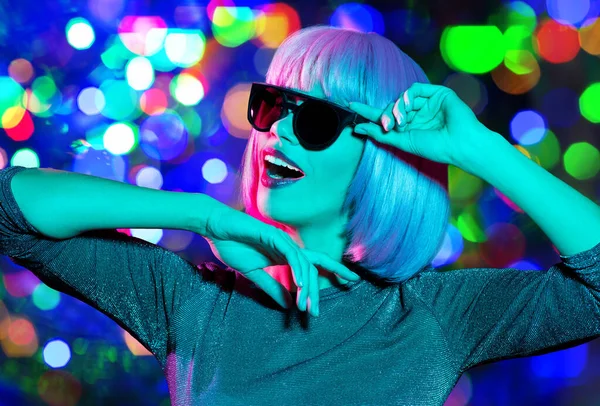 Mujer feliz en peluca rosa y gafas de sol bailando —  Fotos de Stock