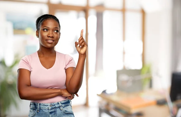 Счастливая африканская американка, указывающая пальцем вверх — стоковое фото