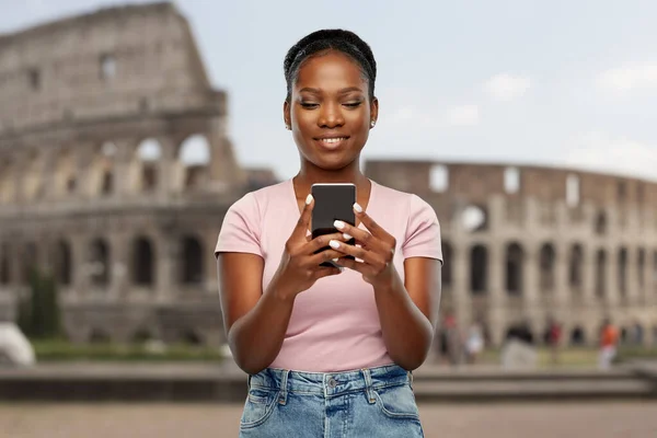 African american woman with smartphone at coliseum — Stockfoto