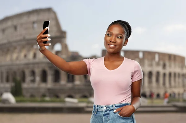 African american woman taking selfie over coliseum — Stockfoto