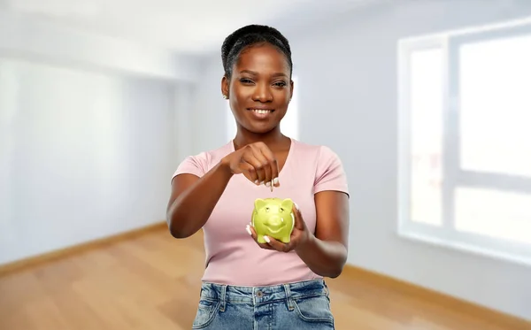 Afro-americana mulher com porquinho banco no novo lar — Fotografia de Stock