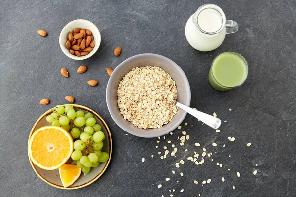 Oatmeal dengan buah-buahan, kacang almond dan kendi susu — Stok Foto