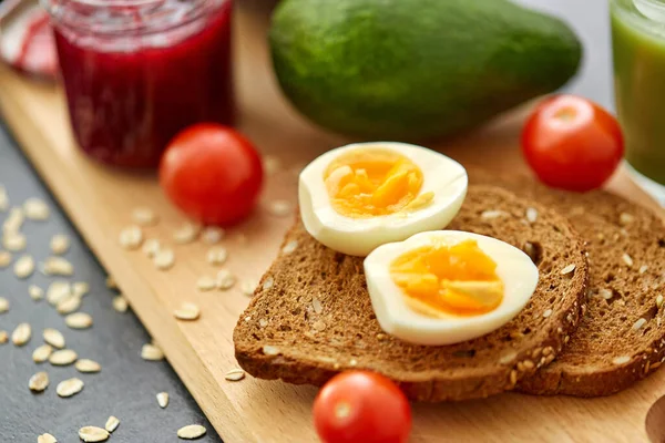 Pão torrado com ovos, tomate cereja e abacate — Fotografia de Stock