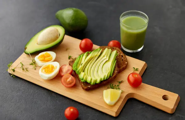 Pan tostado con aguacate, huevos y tomates cherry — Foto de Stock