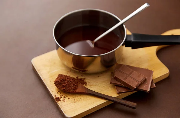 Panci dengan coklat panas yang meleleh dan bubuk kakao — Stok Foto