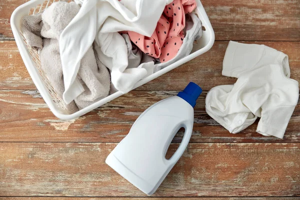Baby clothes in laundry basket with detergent — Stock Photo, Image