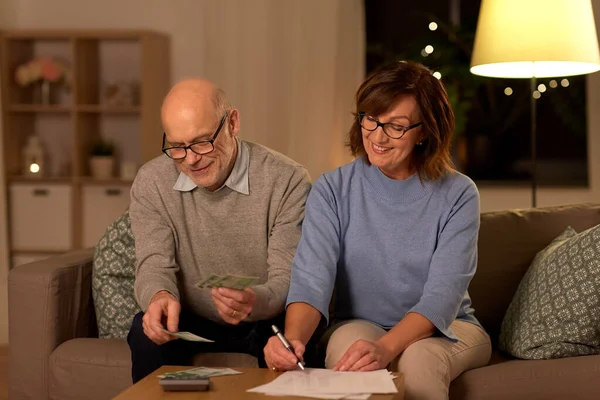 Seniorenpaar met rekeningen tellen geld thuis — Stockfoto