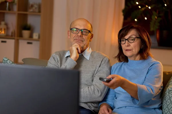 Senioren paar kijken tv thuis in de avond — Stockfoto