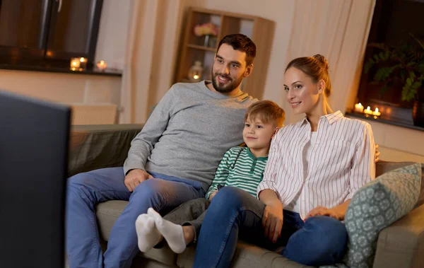 Familia feliz viendo la televisión en casa por la noche —  Fotos de Stock