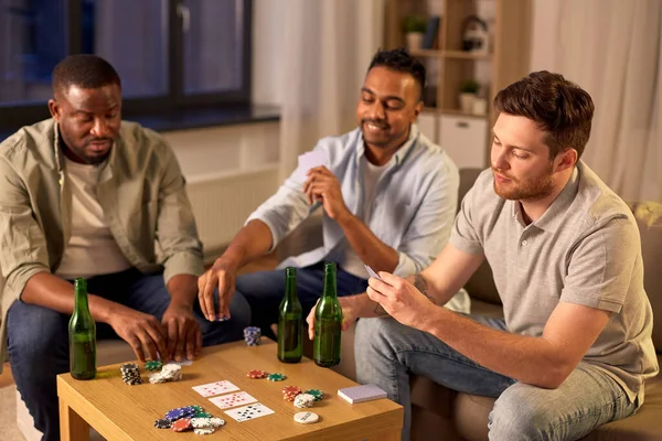 Lächelnde männliche Freunde beim Kartenspielen zu Hause — Stockfoto