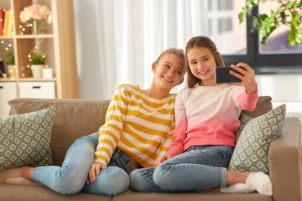 Meninas felizes levando selfie com smartphone em casa — Fotografia de Stock