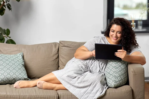 Mulher com computador tablet pc no sofá em casa — Fotografia de Stock