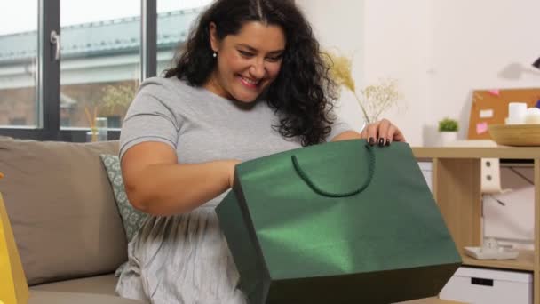 Ευτυχισμένη νεαρή γυναίκα με τσάντα ψώνια στο σπίτι — Αρχείο Βίντεο