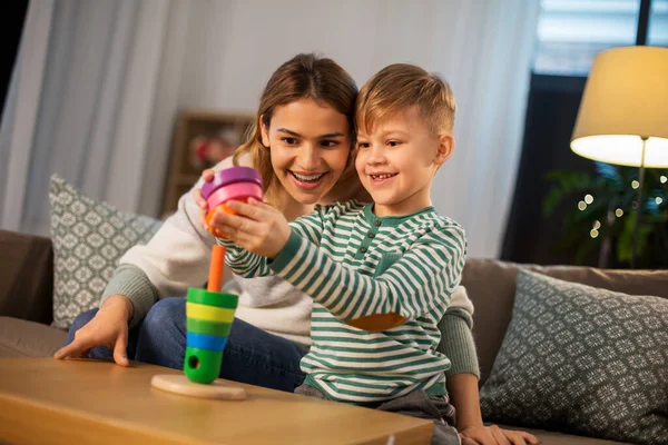 Mother and son playing with toy pyramid at home — Stockfoto