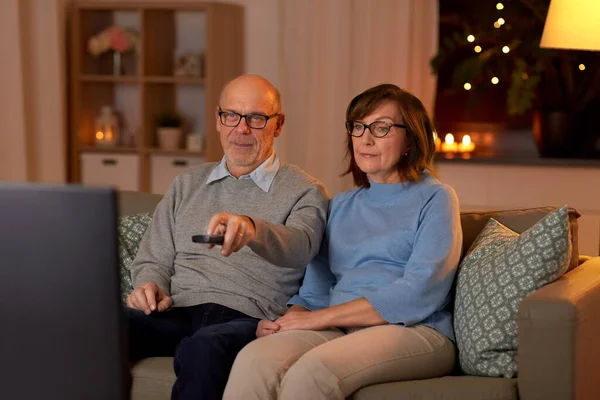 Senioren paar kijken tv thuis in de avond — Stockfoto