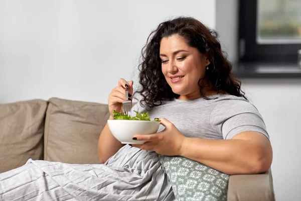 笑顔の若い女性が家で野菜サラダを食べて — ストック写真