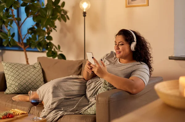 Femme dans casque écoute de la musique sur smartphone — Photo