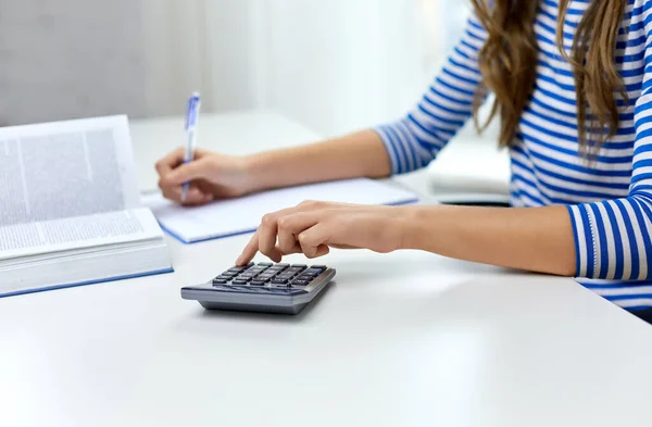 Estudante menina contando com calculadora em casa — Fotografia de Stock