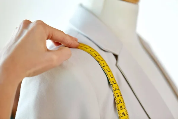 Fashion designer measures jacket with tape measure — Stock Photo, Image