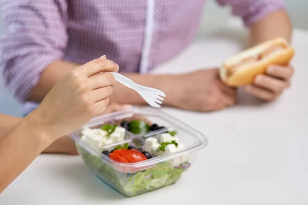 As mãos da mulher que come tiram a comida do container — Fotografia de Stock