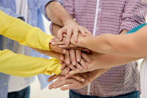 Group of students stacking hands — Stockfoto
