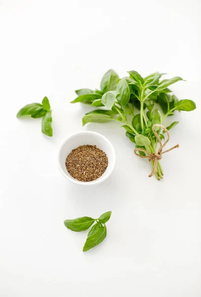 Fresh basil and dry seasoning on white background — Stock Photo, Image