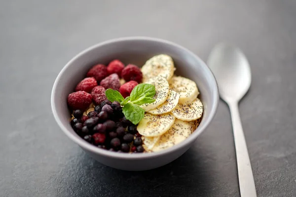 Сніданок з ягодами, бананом і ложкою — стокове фото