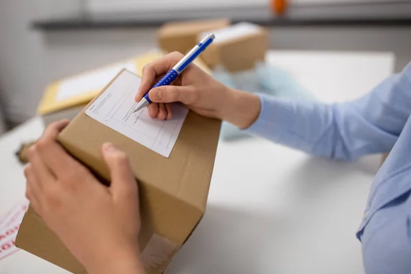 Gros plan de la femme remplissant le formulaire postal au bureau — Photo