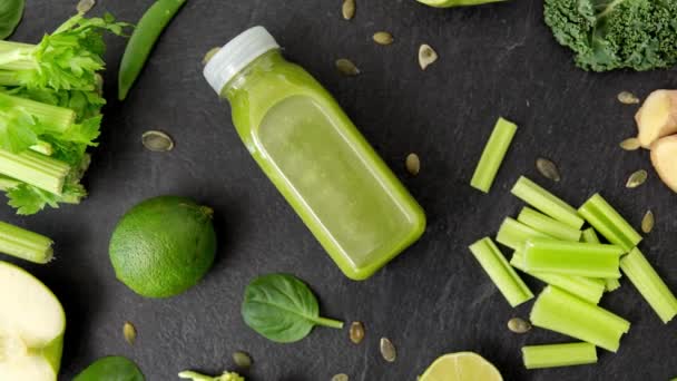 Close up of bottle with green juice and vegetables — Stock Video