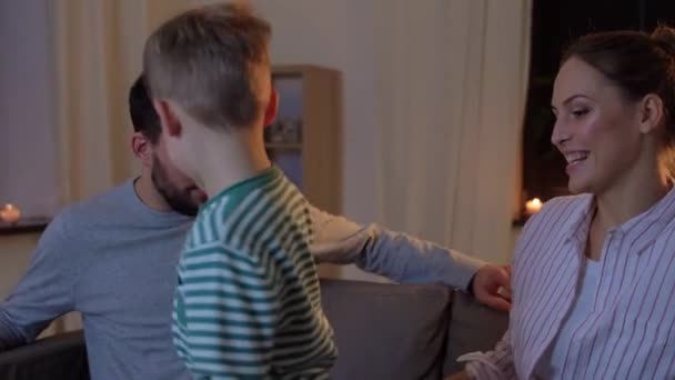 Счастливая семья смотрит телевизор дома по ночам — стоковое видео