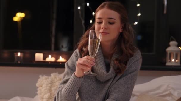 Young woman drinking champagne at home at night — Stock Video