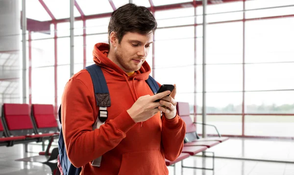 Young man with smartphone and backpack at airport — Φωτογραφία Αρχείου
