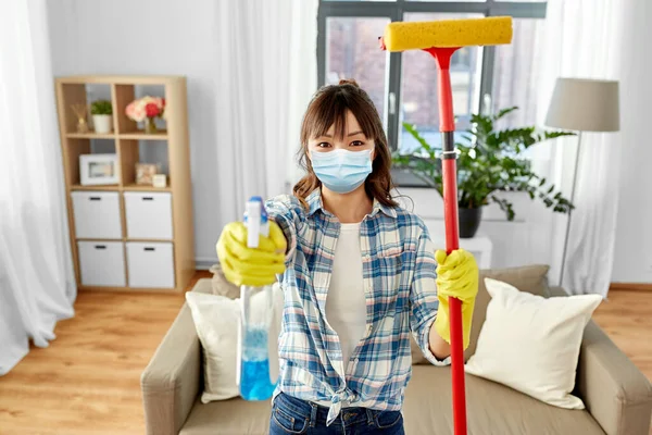 Donna asiatica in maschera protettiva pulizia casa — Foto Stock