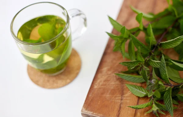 Herbal tea with fresh peppermint on wooden board — Stock Photo, Image