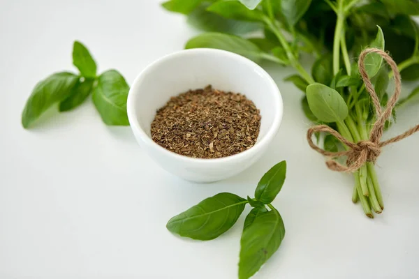 Fresh basil and dry seasoning on white background — Stock Photo, Image