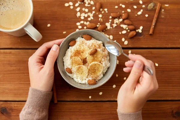 Tangan dengan oatmeal sarapan dan secangkir kopi — Stok Foto
