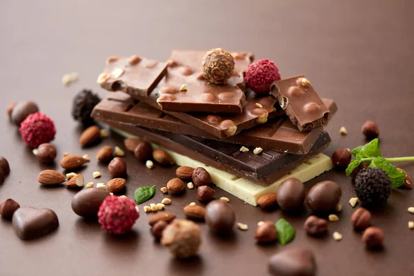 Zblízka různé čokolády, bonbóny a ořechy — Stock fotografie