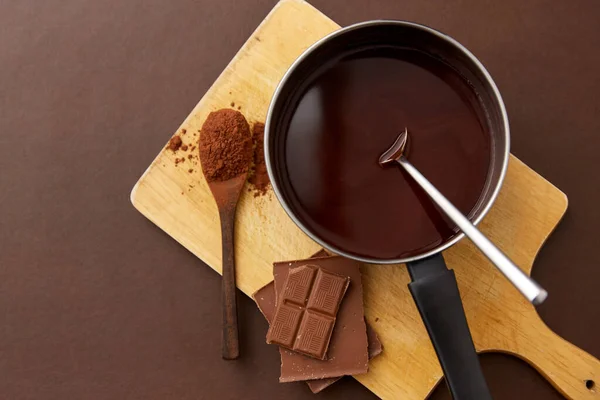 Panci dengan coklat panas yang meleleh dan bubuk kakao — Stok Foto