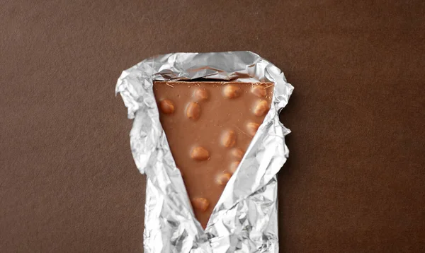 Milk chocolate bar with nuts in foil wrapper — Stock Photo, Image