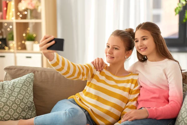 Meninas felizes levando selfie com smartphone em casa — Fotografia de Stock