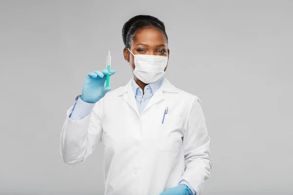 Afrikansk amerikansk kvinnlig läkare med spruta — Stockfoto