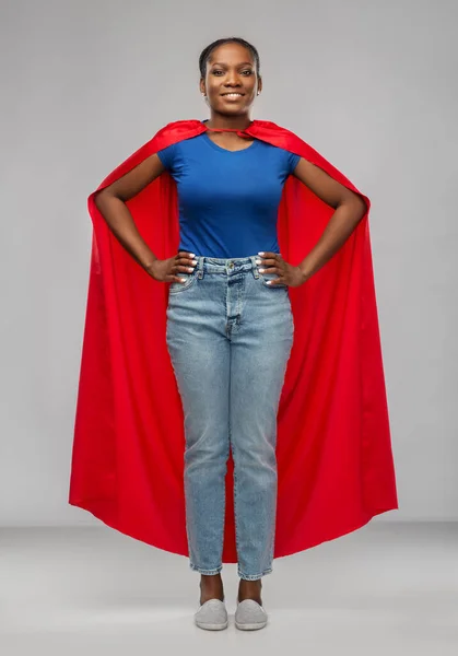 happy african american woman in red superhero cape